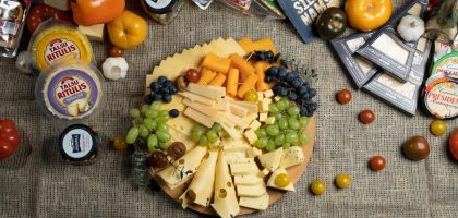 Colorful charcuterie board with assorted cheeses and fresh fruits.